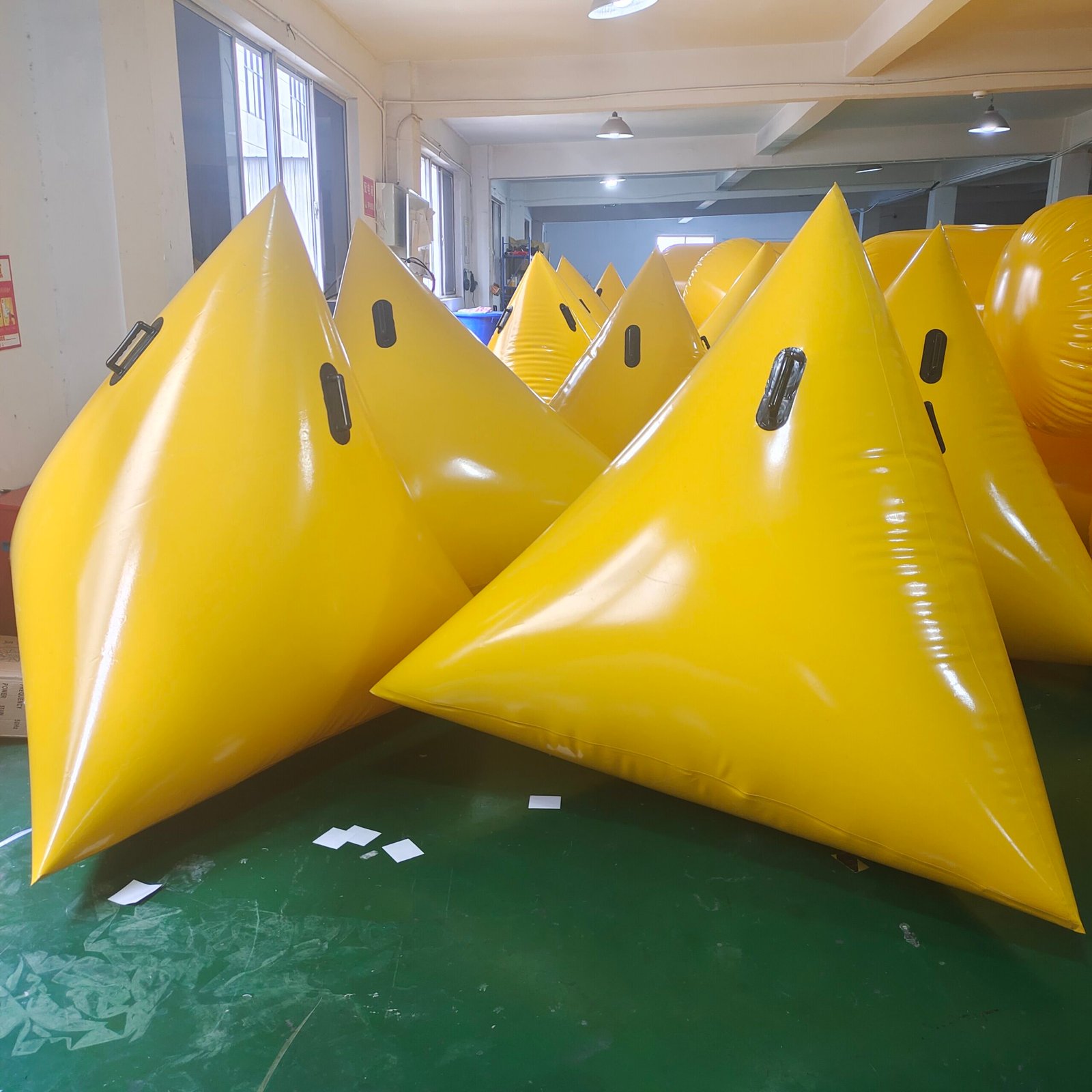 Yellow triangular inflatable marker buoys arranged in a workshop