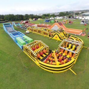 Yellow and black inflatable obstacle course with climbing ramps and tunnels