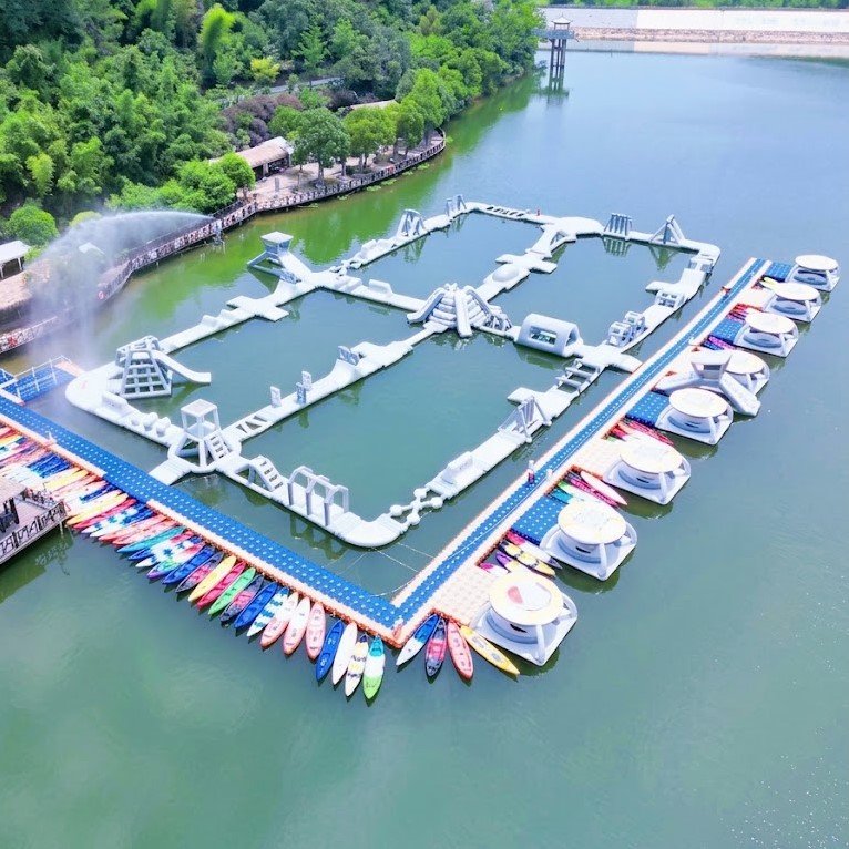 White floating inflatable obstacle course beside rows of moored boats