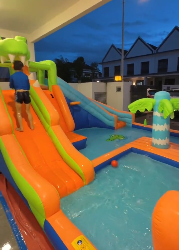Orange and green inflatable water slide leading into a shallow pool