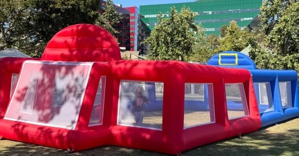 Red and blue inflatable enclosure with mesh side panels