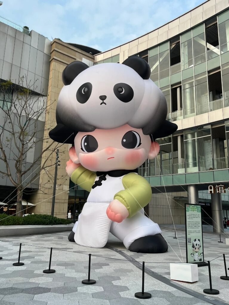 Giant inflatable character wearing a panda costume