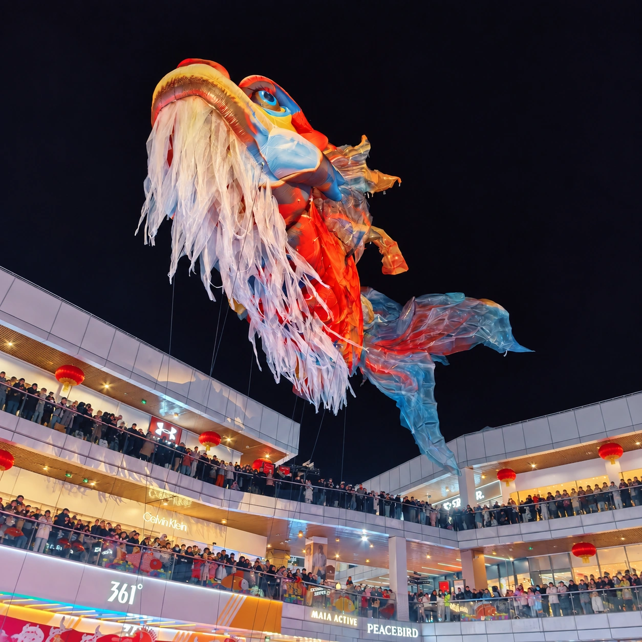 Giant dragon inflatable with long white whiskers above a plaza at night