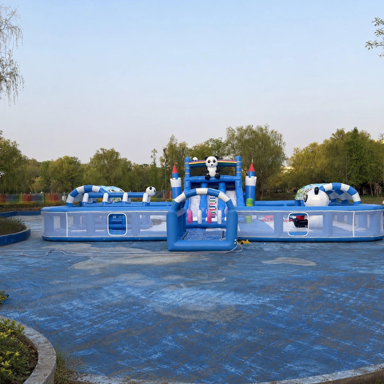 Blue inflatable play structure with a central slide and panda decoration