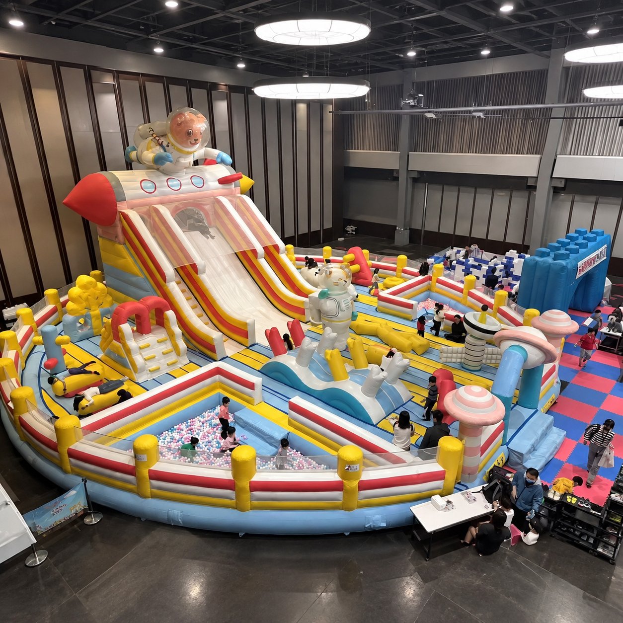 Indoor inflatable playground with an astronaut-themed slide and colorful walls