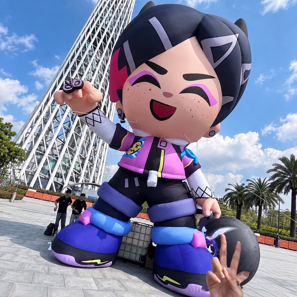 Inflatable cartoon character with dark hair, purple shoes, and a pink jacket