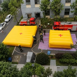 Two yellow inflatable rescue cushions beside fire trucks