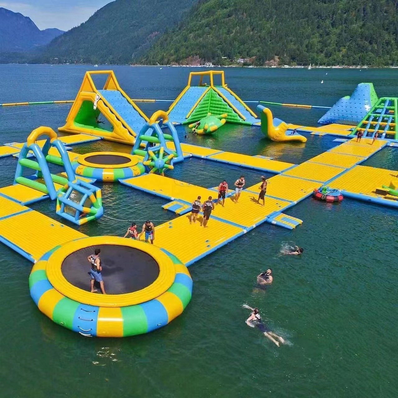 Yellow and green floating inflatable park with slides and circular trampolines