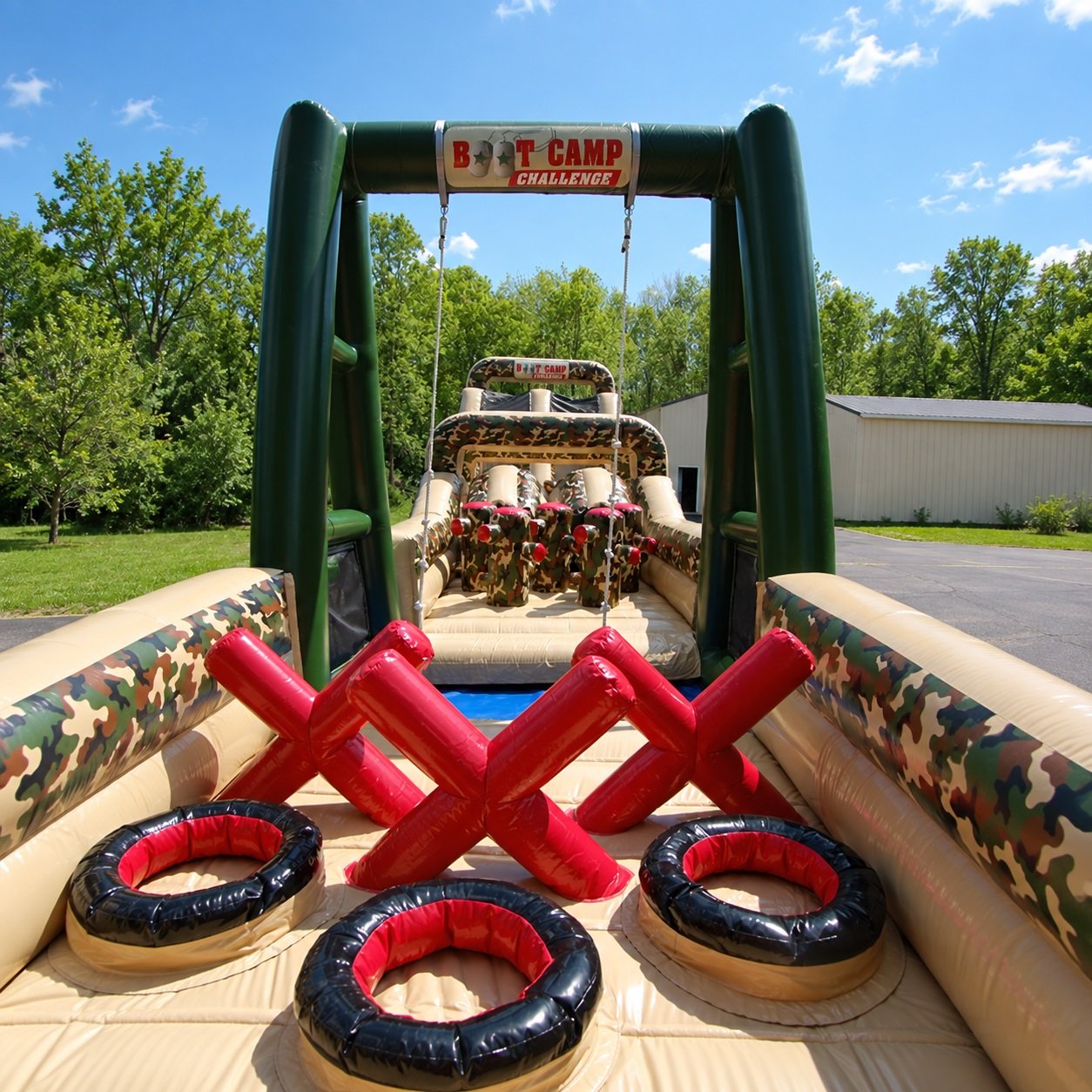 Camouflage-themed inflatable obstacle course with tire shapes and red barriers