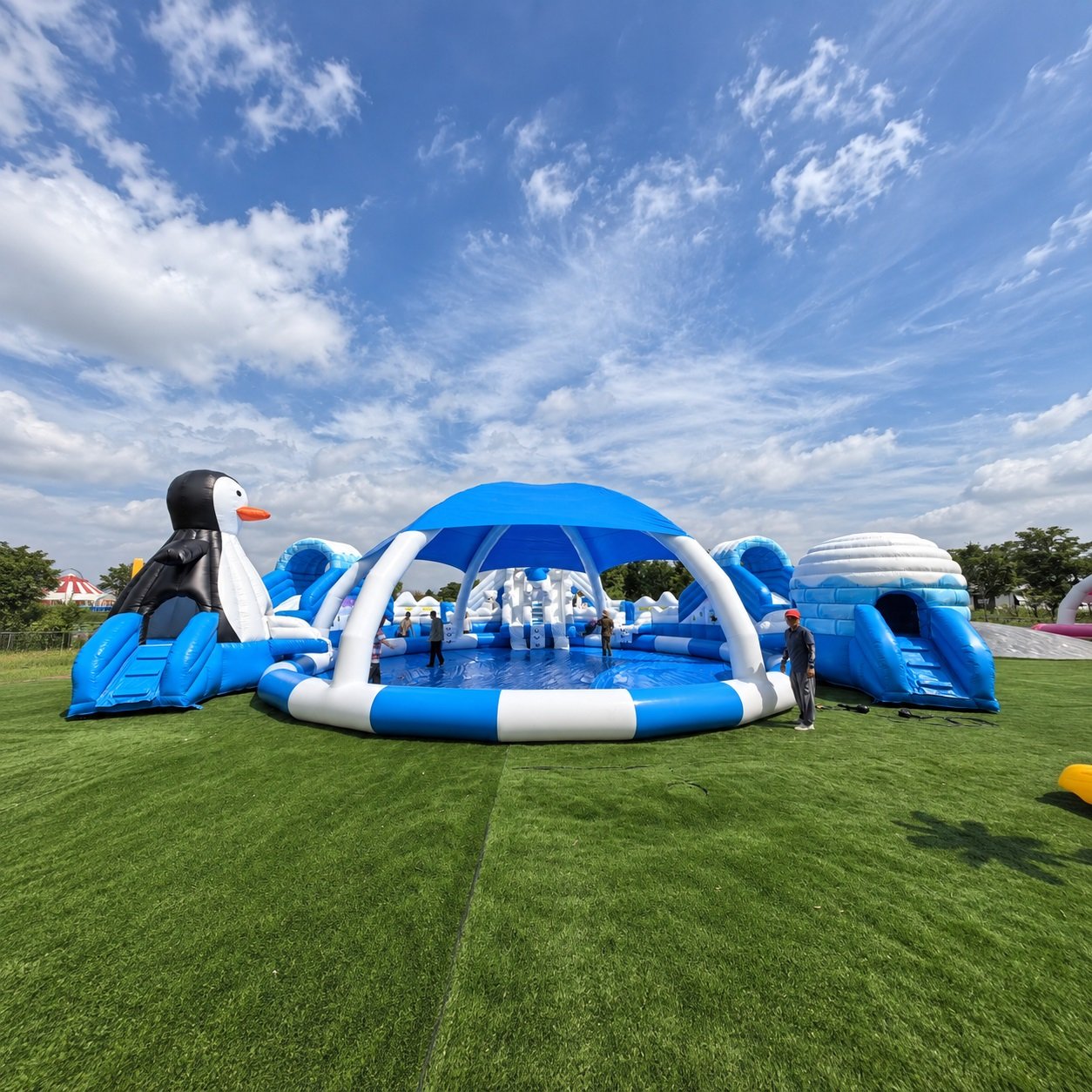 Blue and white inflatable water play area with a central canopy and penguin decoration