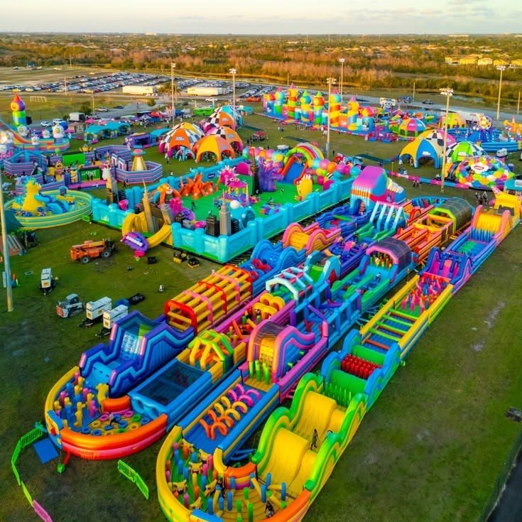 Aerial view of a large inflatable park with colorful obstacle courses and slides