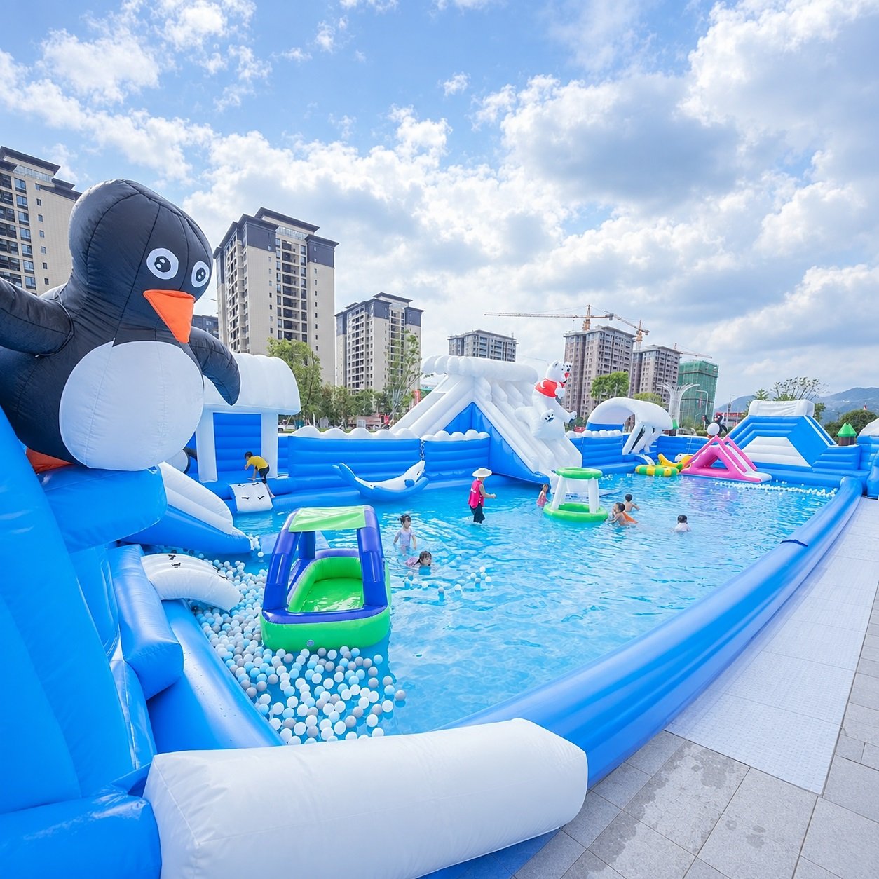 Penguin-themed inflatable water park with slides and a large blue pool
