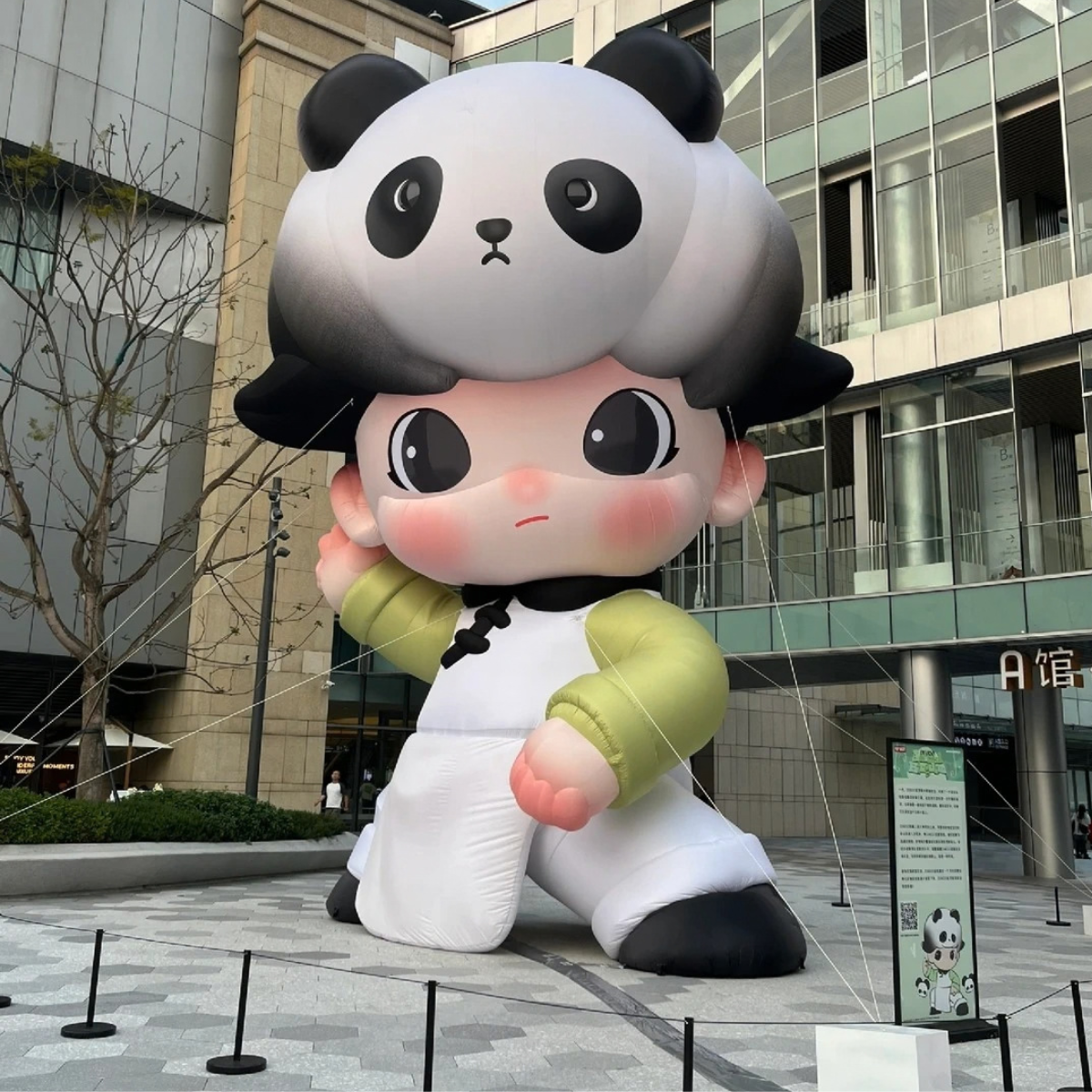 Giant inflatable character wearing a panda costume