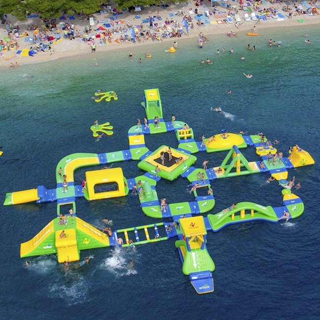 Aerial view of a yellow and green floating inflatable obstacle course