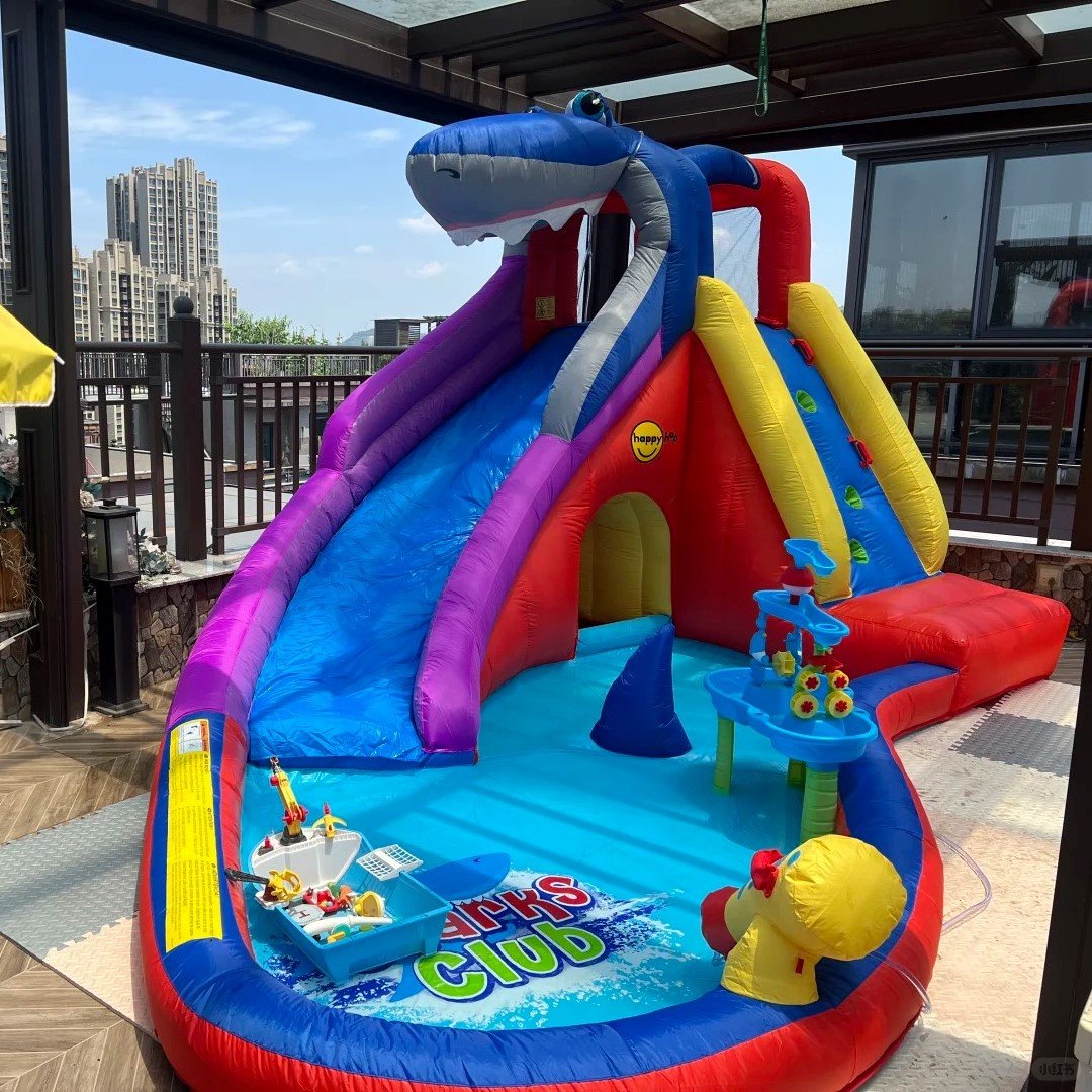 Shark-themed inflatable water slide with a shallow splash pool