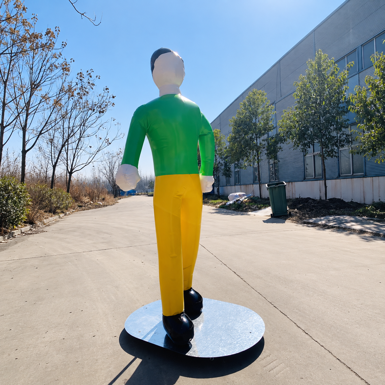 Inflatable human mannequin wearing a green shirt and yellow pants