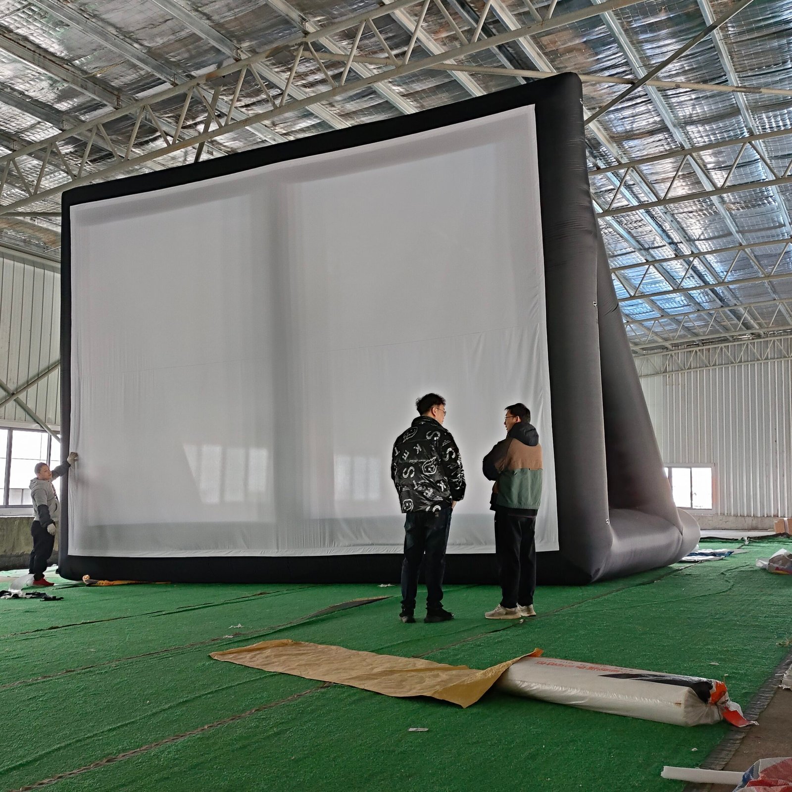 Black-framed inflatable projection screen with people standing in front