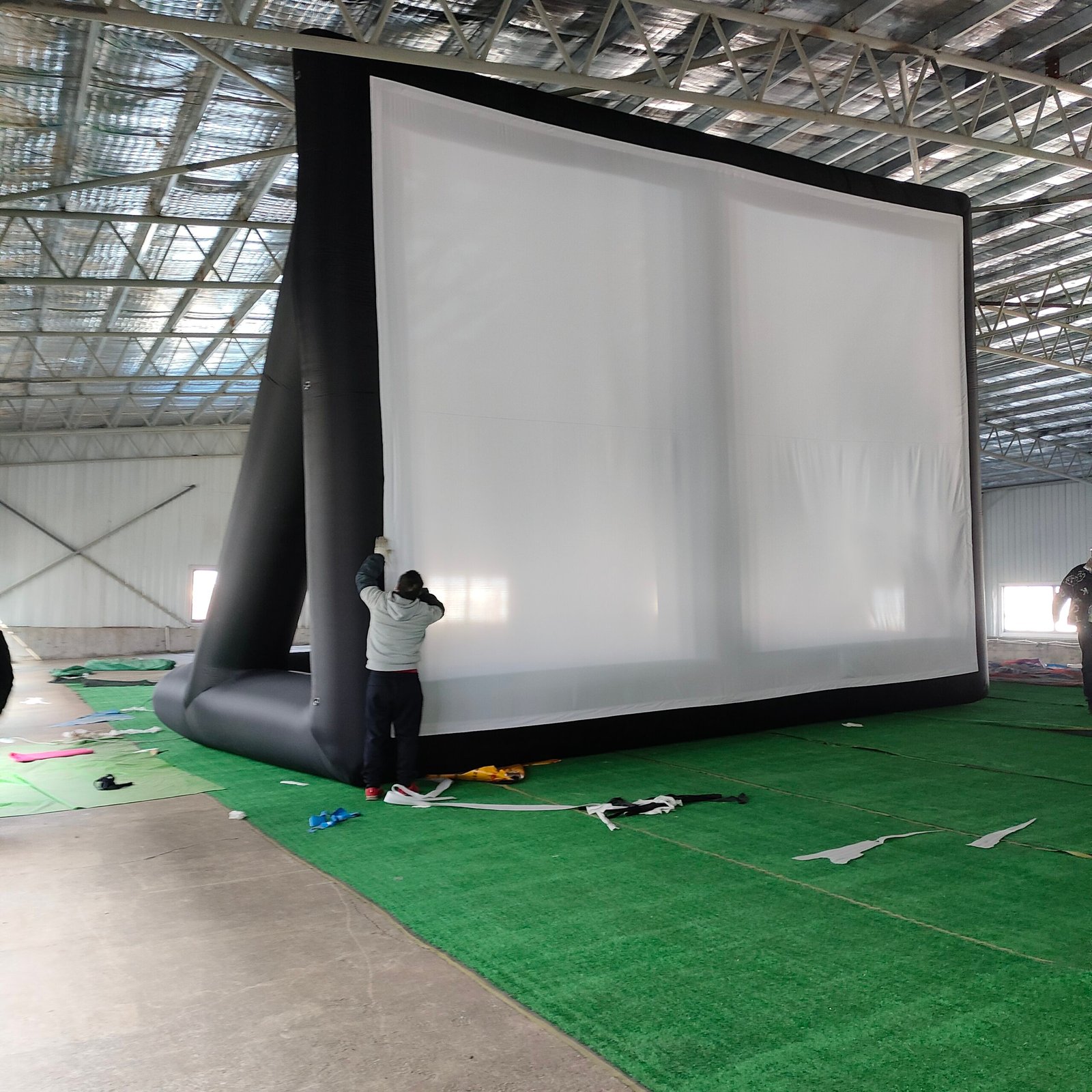 Tall black inflatable projection screen beside a person