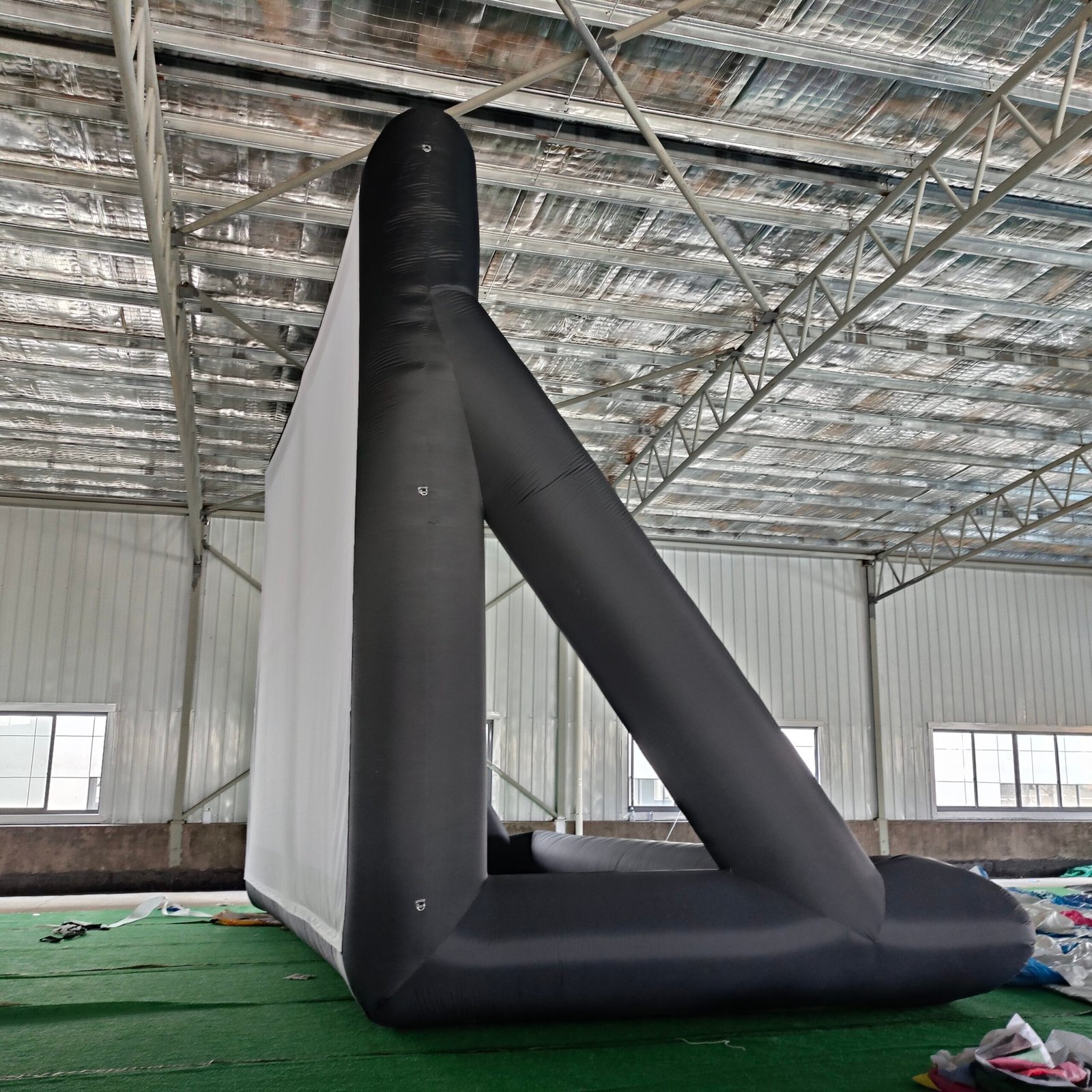 Side view of a black inflatable projection screen and rear support