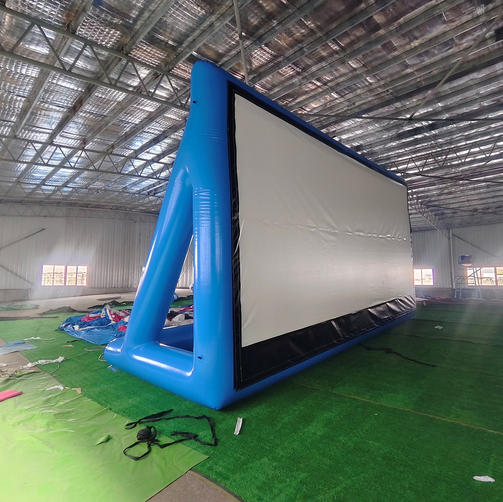 Blue inflatable projection screen with rear support legs viewed at an angle