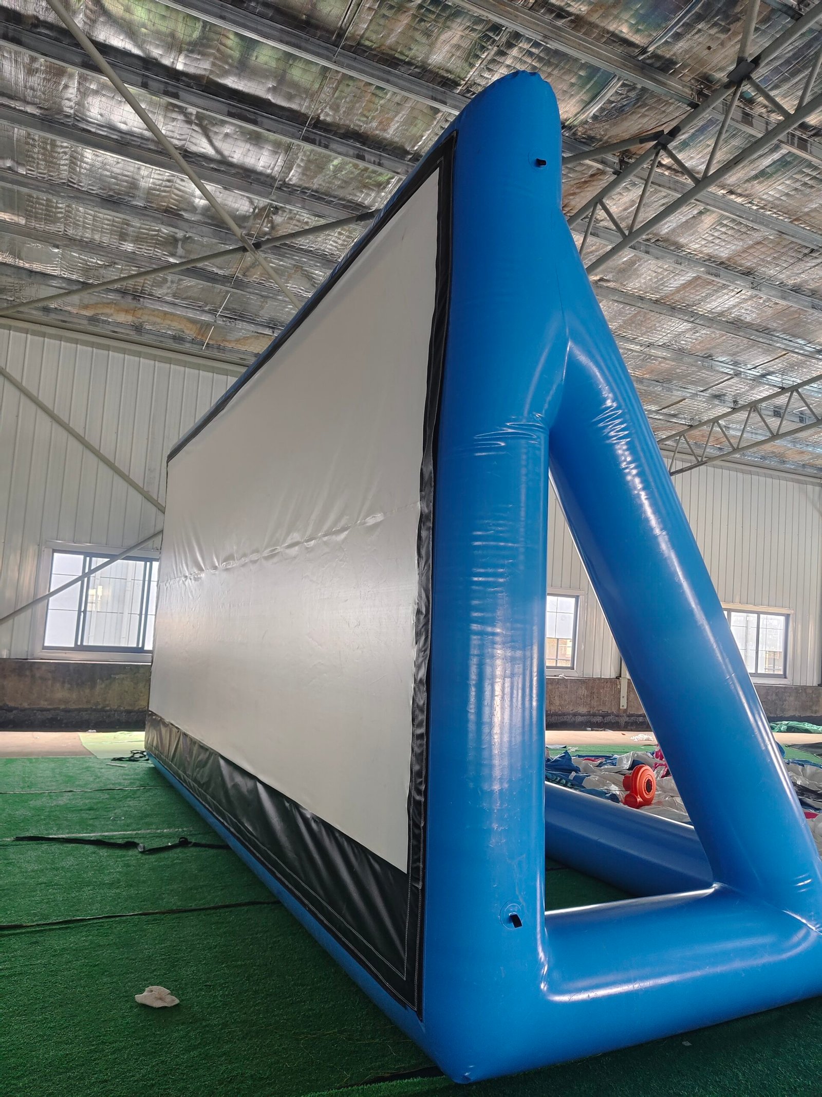 Side view of a blue inflatable projection screen and triangular support