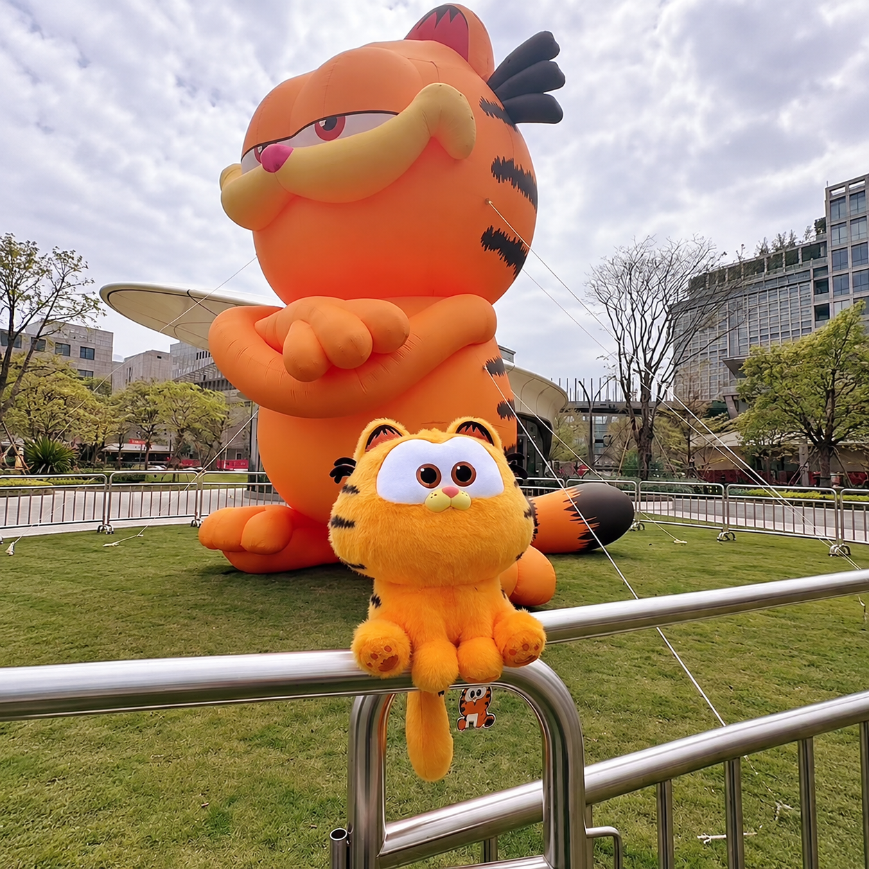 Giant orange inflatable cartoon cat with crossed arms