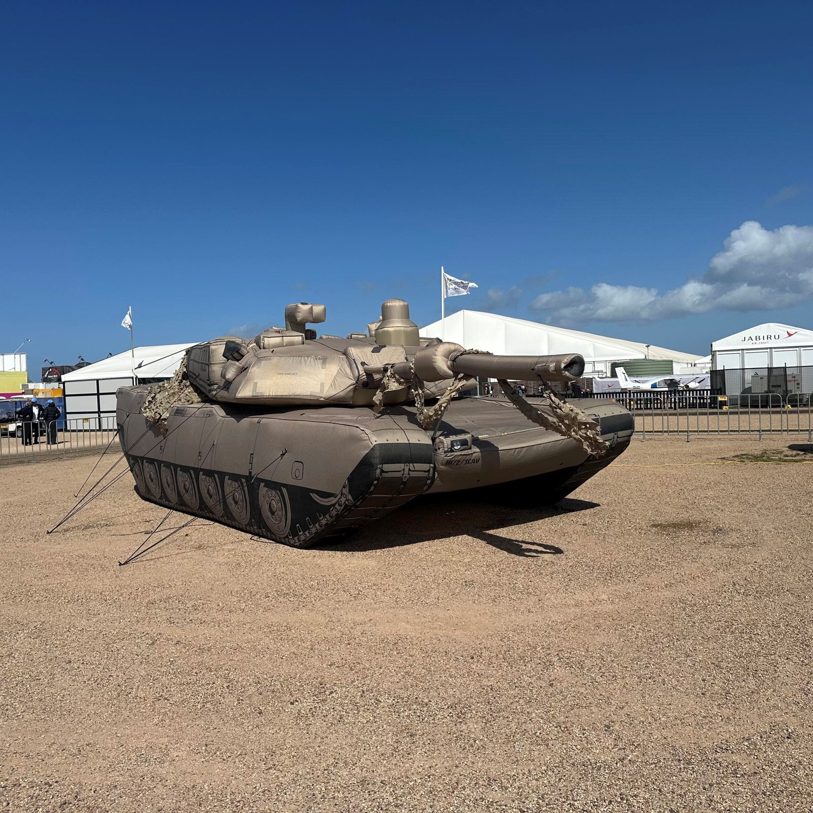Tan inflatable tank model displayed on bare ground