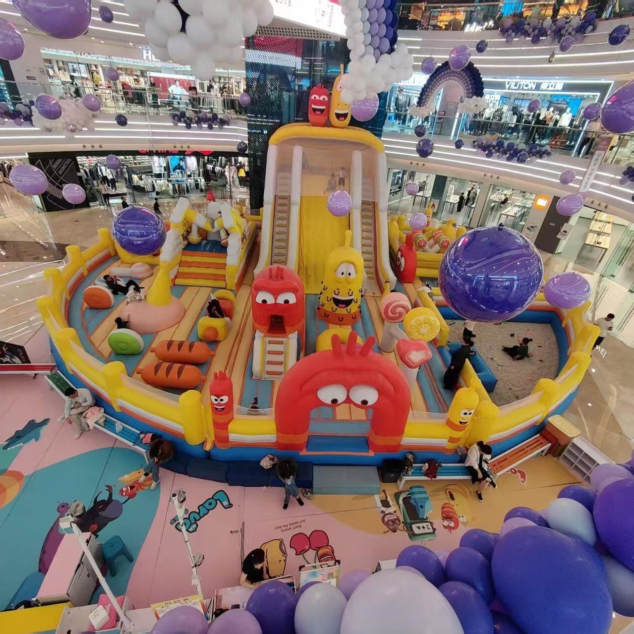Colorful inflatable playground with cartoon decorations in a shopping mall