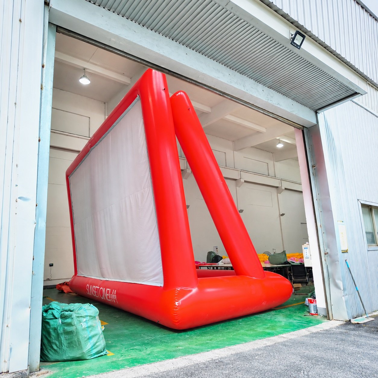 Side view of a red inflatable projection screen with triangular rear supports
