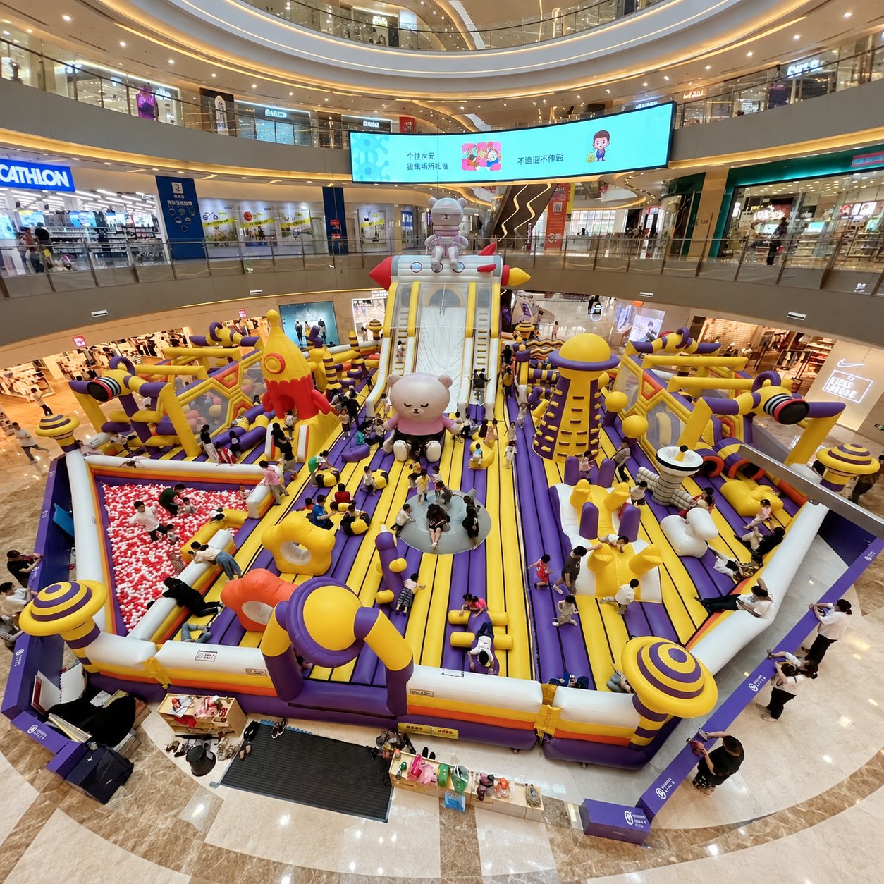 Large indoor inflatable playground with slides, obstacles, and ball pits